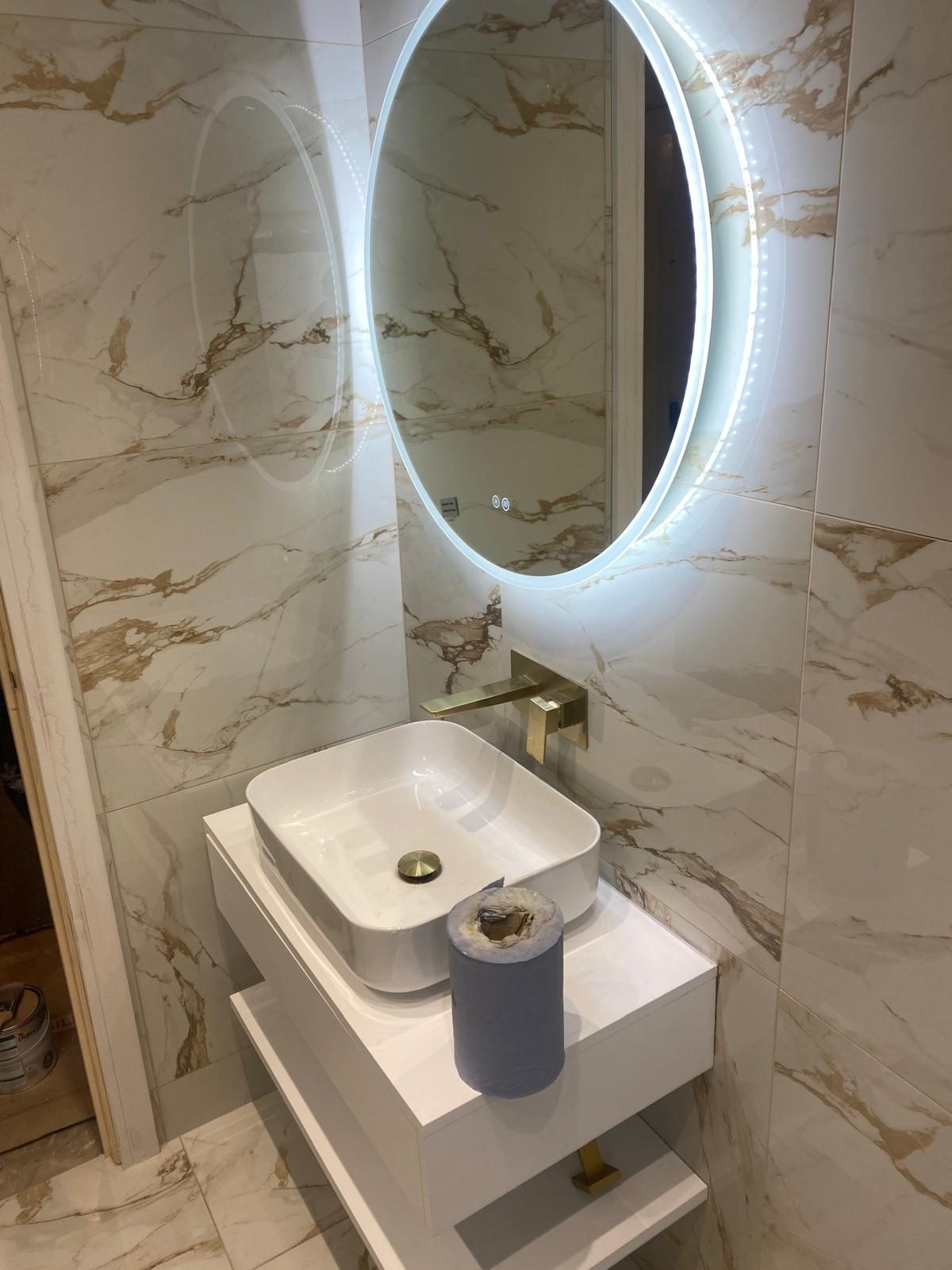 Countertop basin with brushed gold wall tap and LED mirror